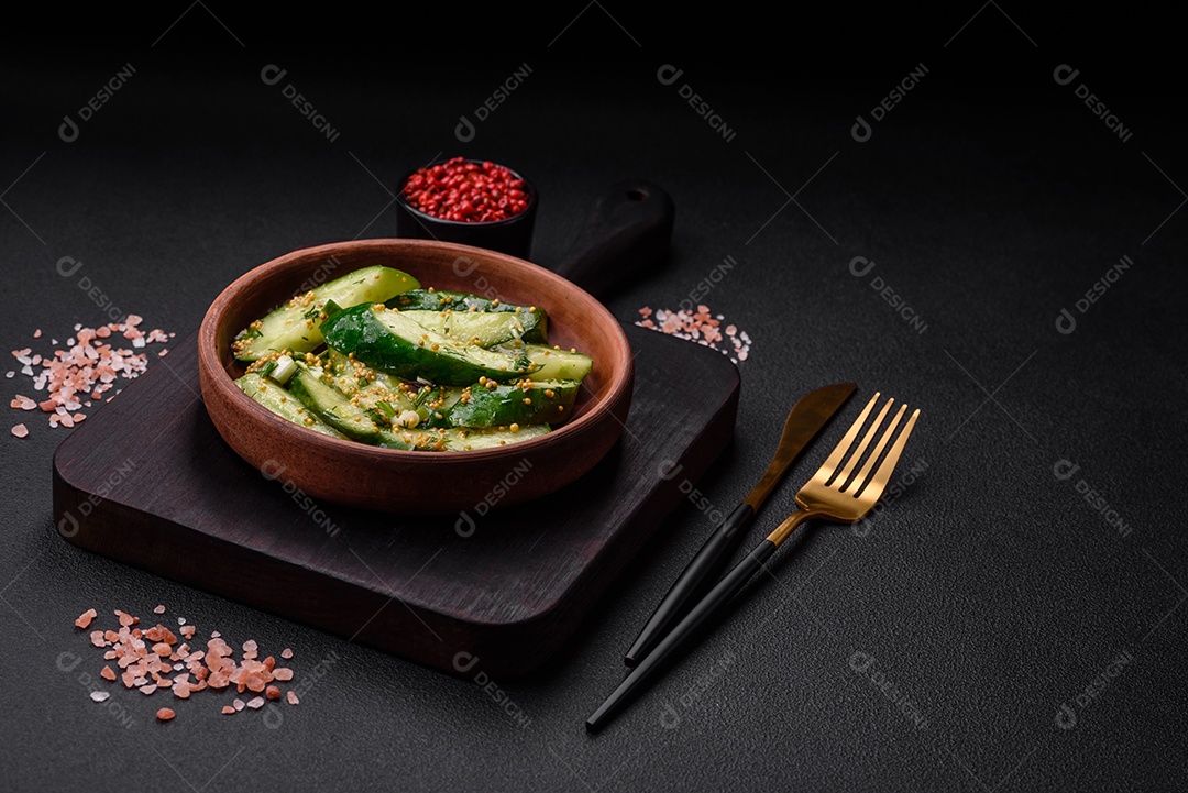 Delicioso pepino suculento cortado em grandes fatias com sal, especiarias e mostarda francesa sobre um fundo escuro de concreto