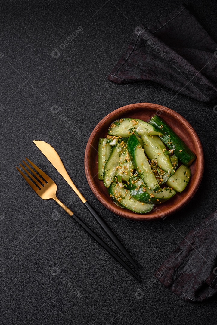 Delicioso pepino suculento cortado em grandes fatias com sal, especiarias e mostarda francesa sobre um fundo escuro de concreto