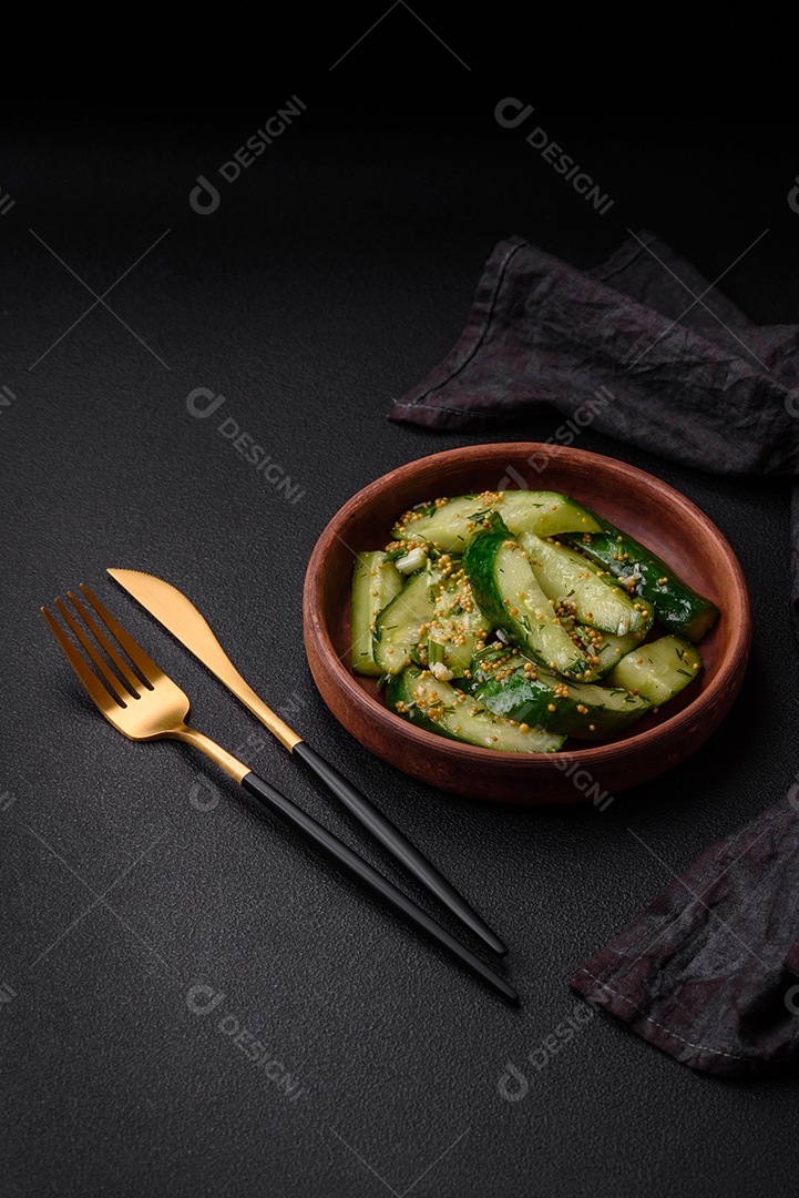 Delicioso pepino suculento cortado em grandes fatias com sal, especiarias e mostarda francesa sobre um fundo escuro de concreto