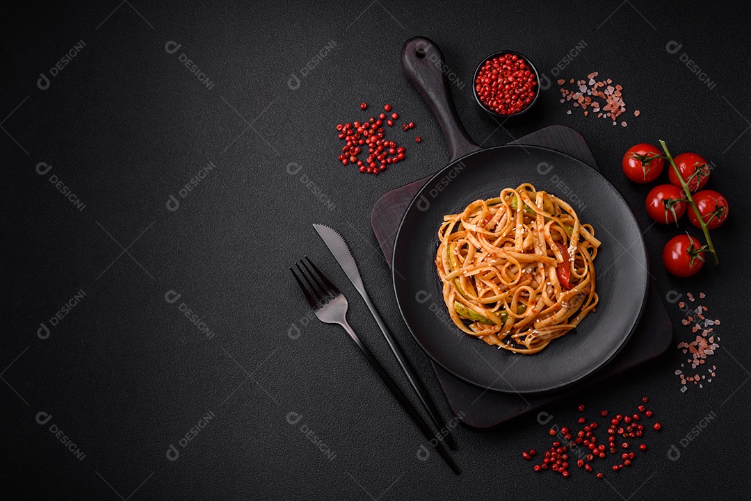Delicioso prato de udon asiático com legumes, cogumelos, sal e especiarias numa placa cerâmica sobre um fundo escuro de concreto