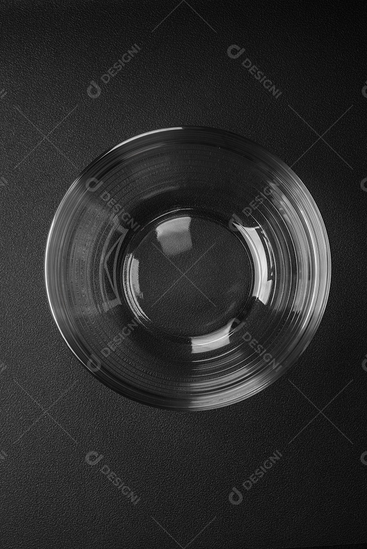 Copo de vidro transparente como elemento de utensílios de cozinha para cozinhar em casa sobre um fundo escuro de concreto