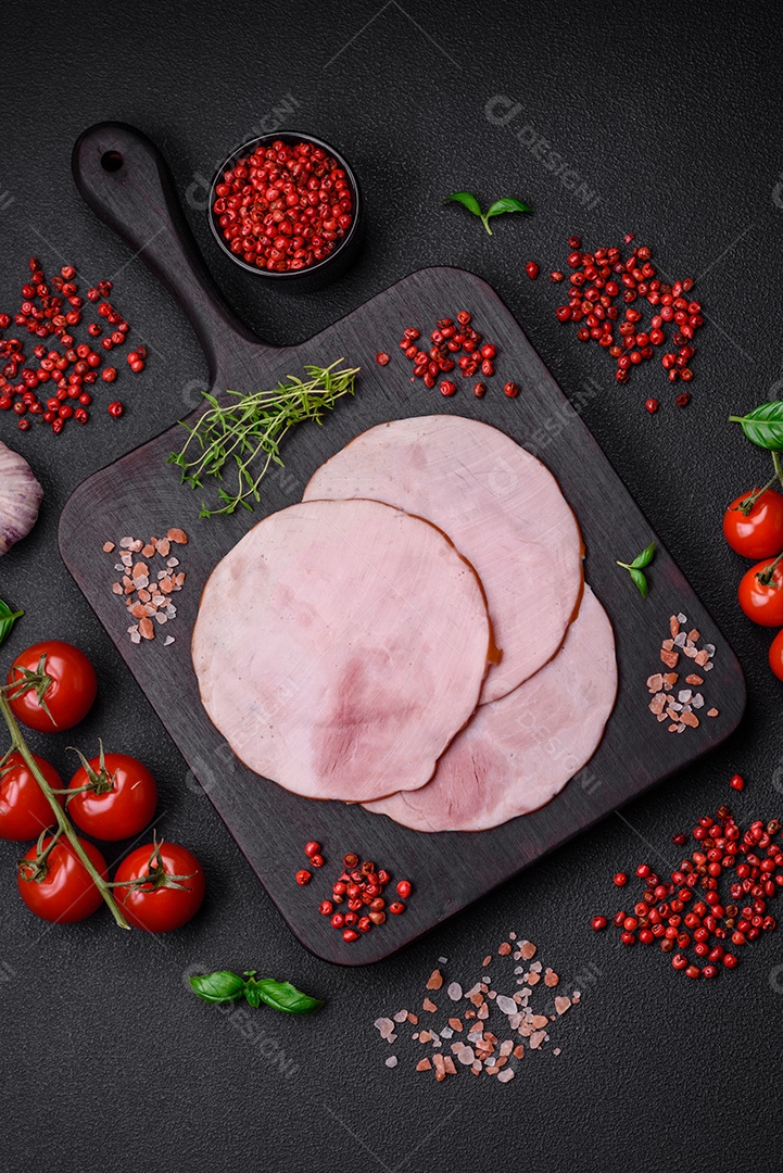 Delicioso presunto fresco cortado em fatias redondas com sal, especiarias e ervas sobre fundo escuro de concreto