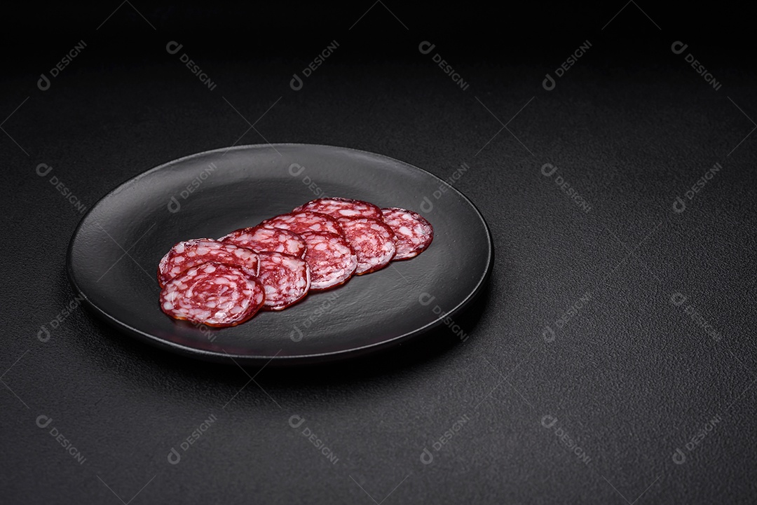 Deliciosa linguiça defumada com bacon, sal, especiarias e ervas cortadas em fatias sobre uma tábua de madeira