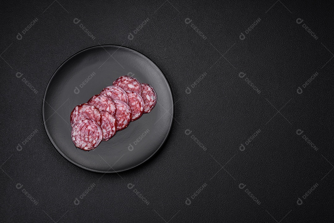 Deliciosa linguiça defumada com bacon, sal, especiarias e ervas cortadas em fatias sobre uma tábua de madeira