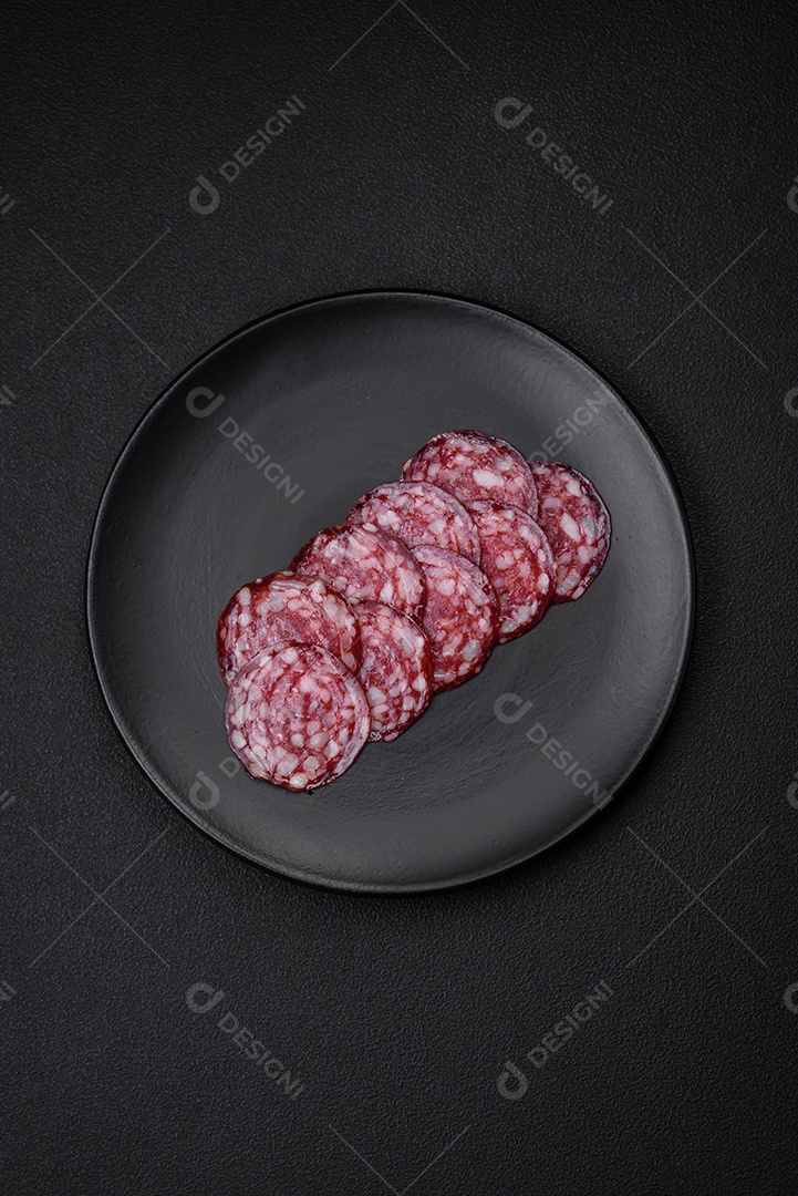 Deliciosa linguiça defumada com bacon, sal, especiarias e ervas cortadas em fatias sobre uma tábua de madeira