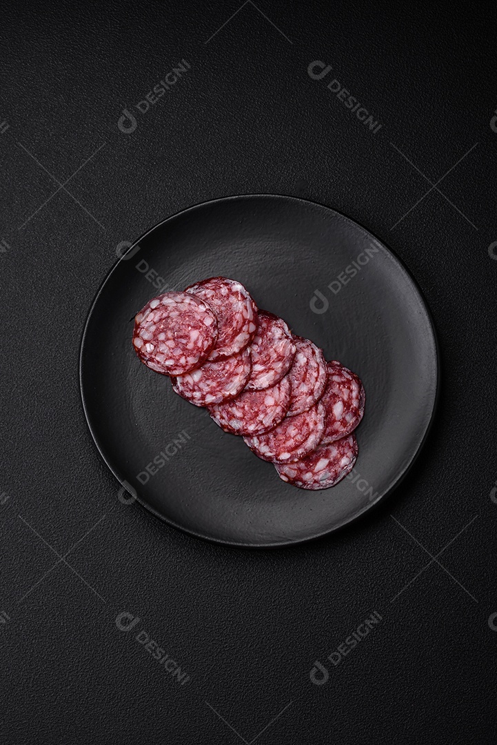 Deliciosa linguiça defumada com bacon, sal, especiarias e ervas cortadas em fatias sobre uma tábua de madeira