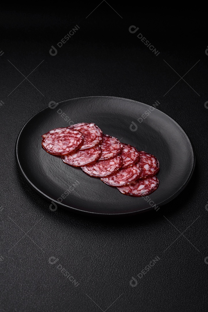 Deliciosa linguiça defumada com bacon, sal, especiarias e ervas cortadas em fatias sobre uma tábua de madeira