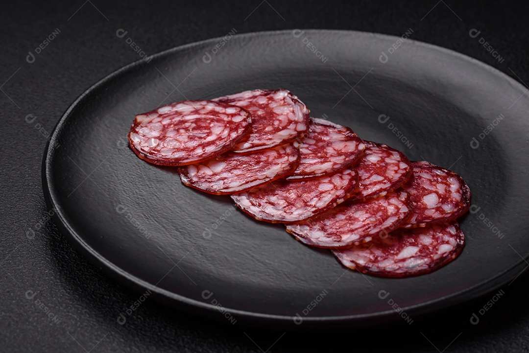 Deliciosa linguiça defumada com bacon, sal, especiarias e ervas cortadas em fatias sobre uma tábua de madeira