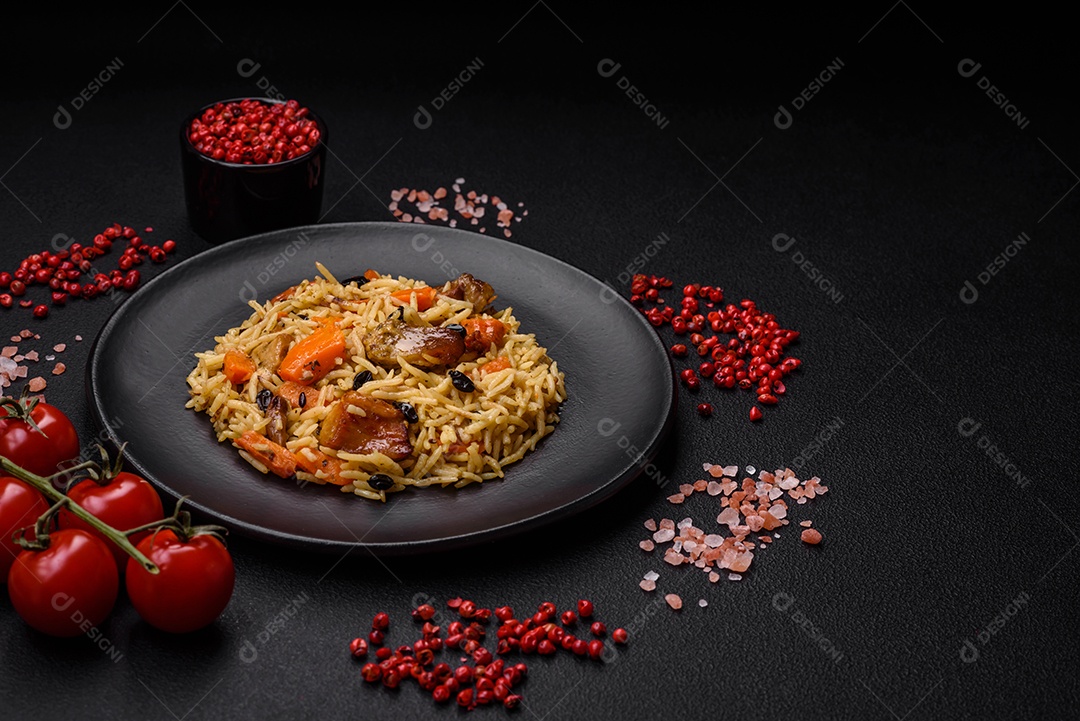 Delicioso pilaf fresco com arroz, cenoura, carne, cebola, especiarias e bagas num prato cerâmico sobre um fundo escuro de concreto