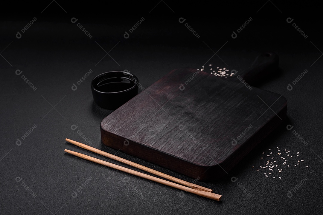 Deliciosas lulas secas em forma de lascas com sal e especiarias numa placa cerâmica sobre um fundo escuro de concreto