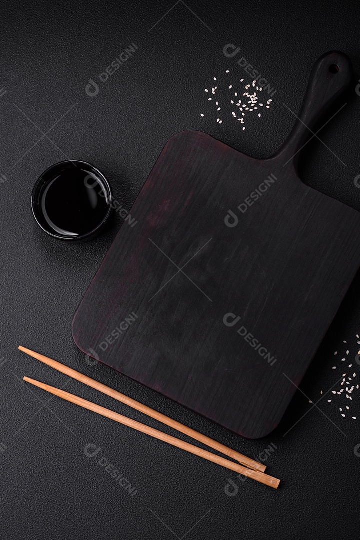 Deliciosas lulas secas em forma de lascas com sal e especiarias numa placa cerâmica sobre um fundo escuro de concreto