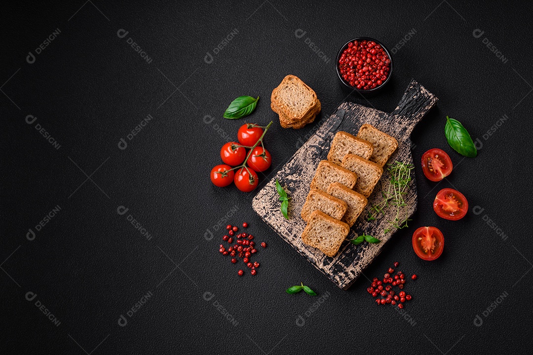 Deliciosos croutons de trigo retangulares salgados com sal e especiarias sobre um fundo escuro de concreto