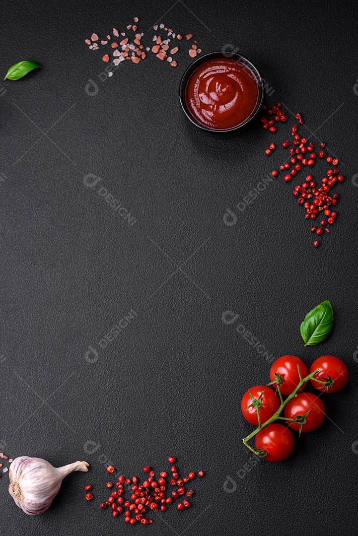 Ingredientes para cozinhar tomate cereja, sal, especiarias e ervas sobre um fundo escuro de concreto