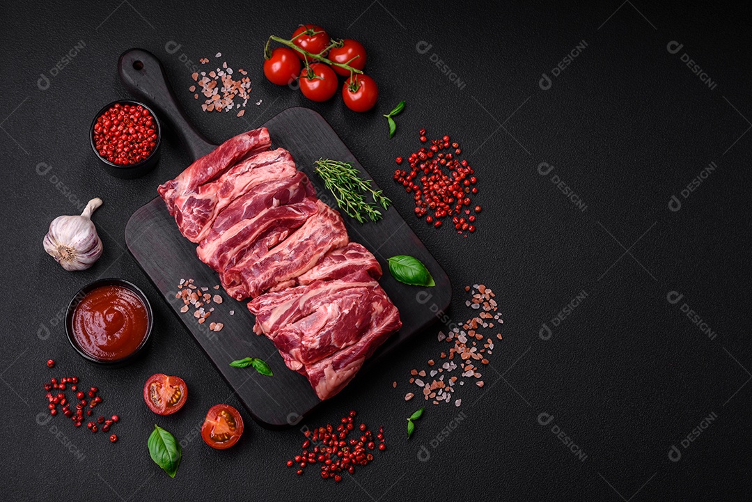 Costelas de carne crua fresca com sal, especiarias e ervas preparadas para grelhar