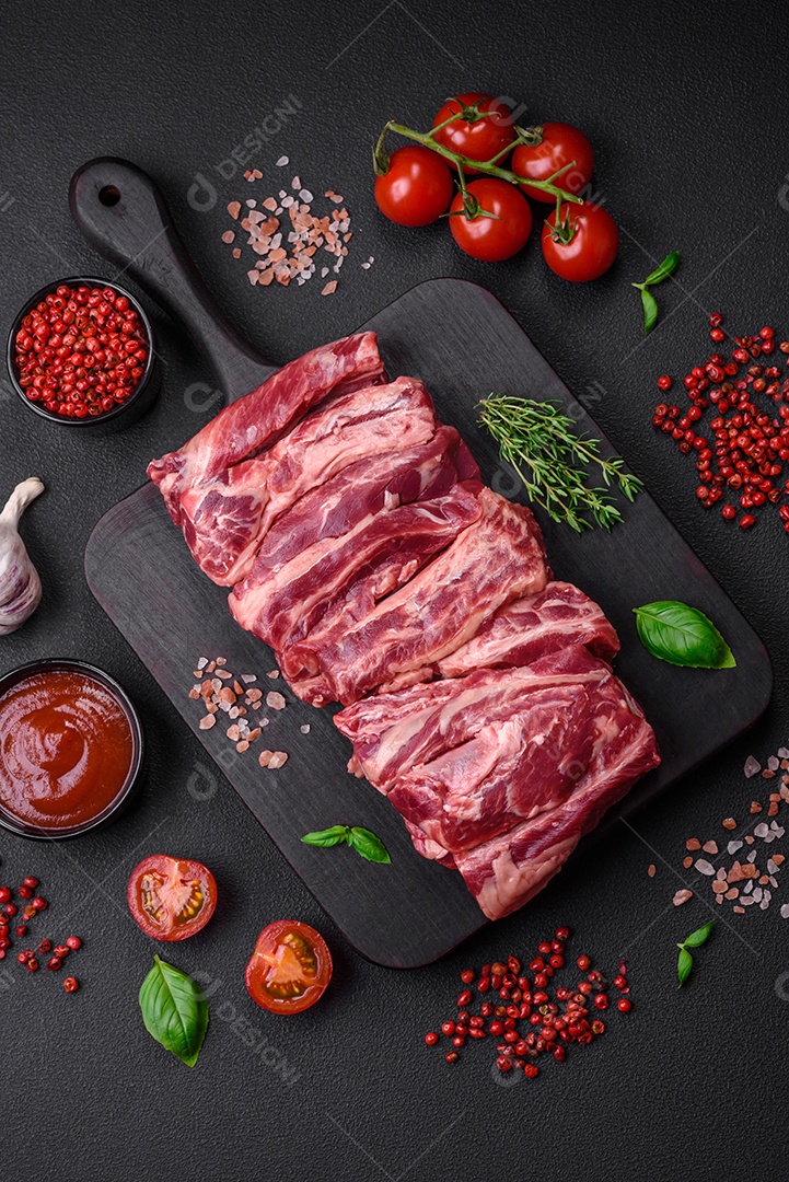 Costelas de carne crua fresca com sal, especiarias e ervas preparadas para grelhar