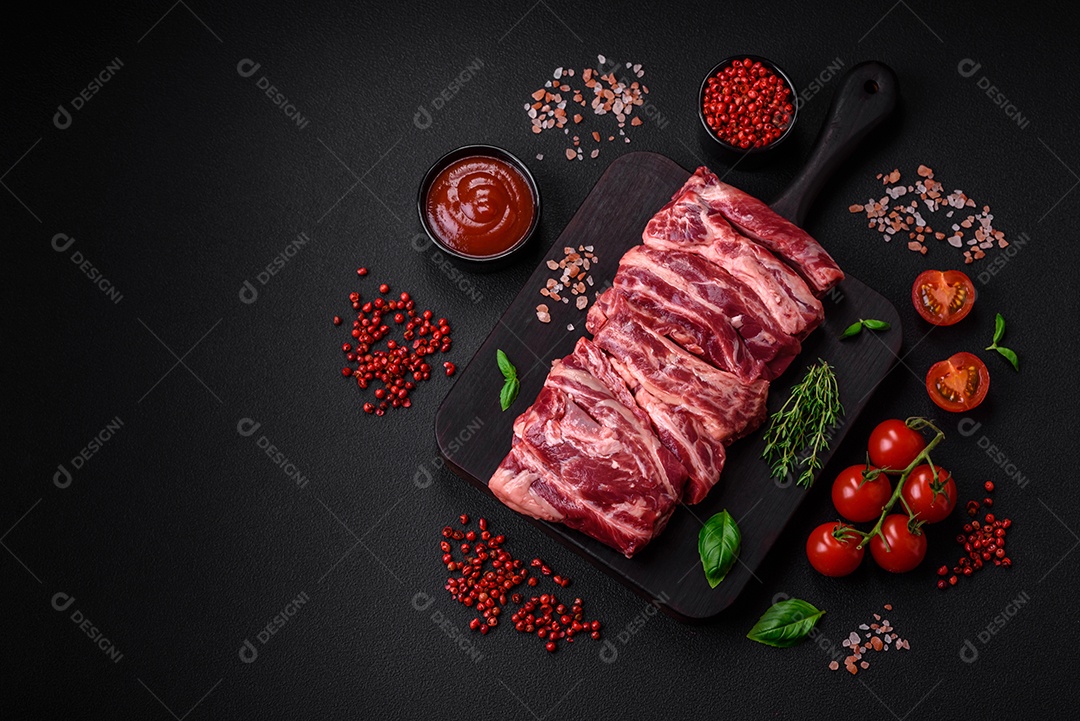 Costelas de carne crua fresca com sal, especiarias e ervas preparadas para grelhar