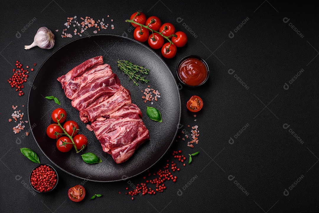 Costelas de carne crua fresca com sal, especiarias e ervas preparadas para grelhar