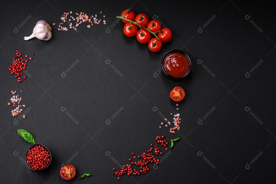 Ingredientes para cozinhar tomate cereja, sal, especiarias e ervas sobre um fundo escuro de concreto