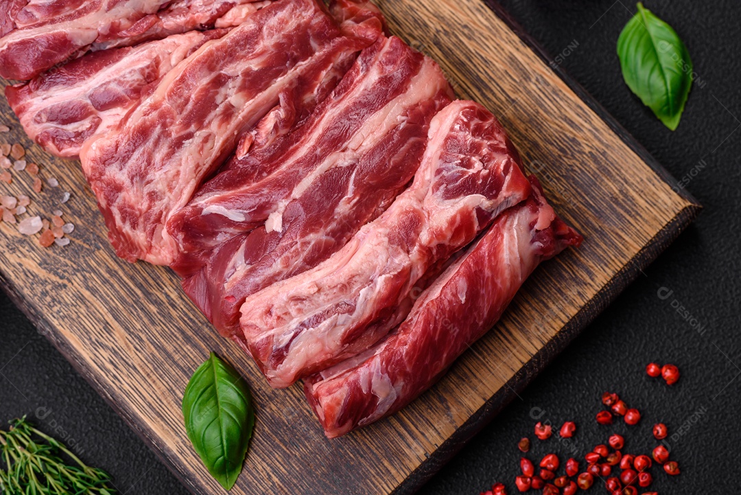 Ingredientes para cozinhar tomate cereja, sal, especiarias e ervas sobre um fundo escuro de concreto