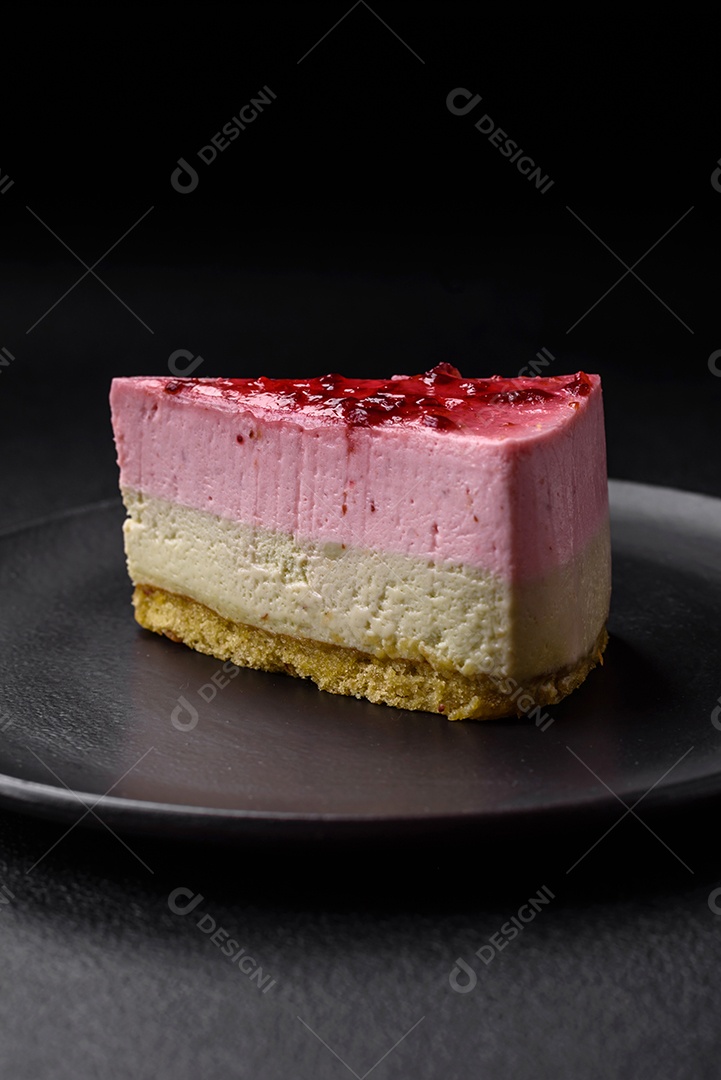 Delicioso cheesecake de sobremesa doce com sabor de framboesa e pistache em fundo de concreto texturizado