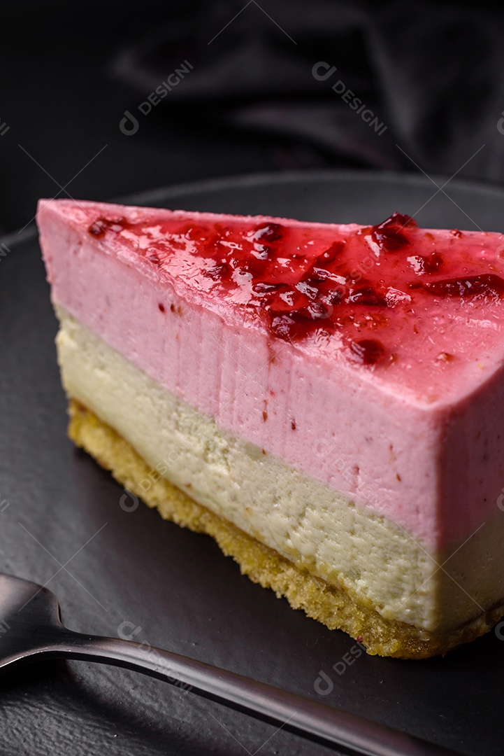 Delicioso cheesecake de sobremesa doce com sabor de framboesa e pistache em fundo de concreto texturizado