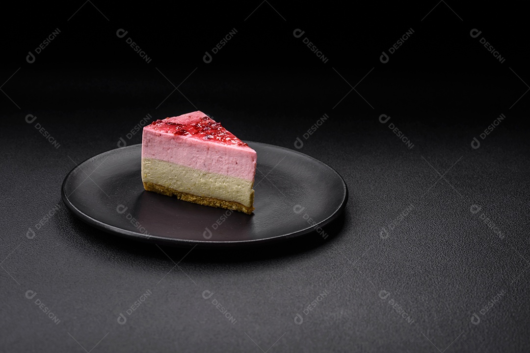 Delicioso cheesecake de sobremesa doce com sabor de framboesa e pistache em fundo de concreto texturizado