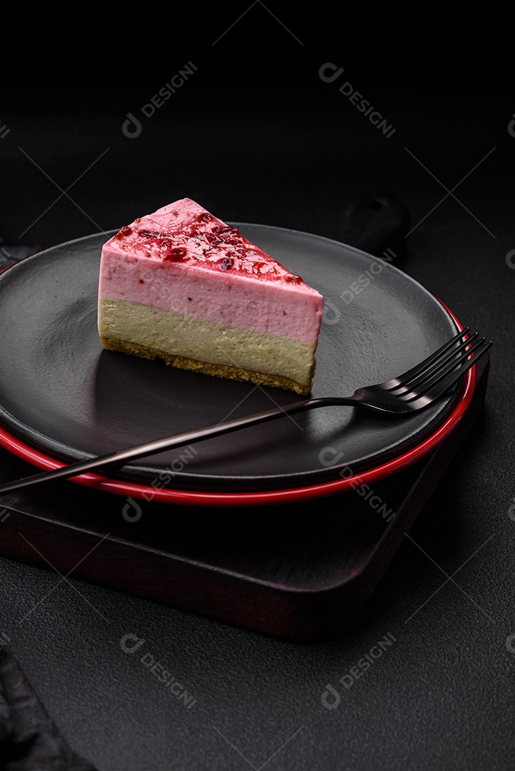 Delicioso cheesecake de sobremesa doce com sabor de framboesa e pistache em fundo de concreto texturizado