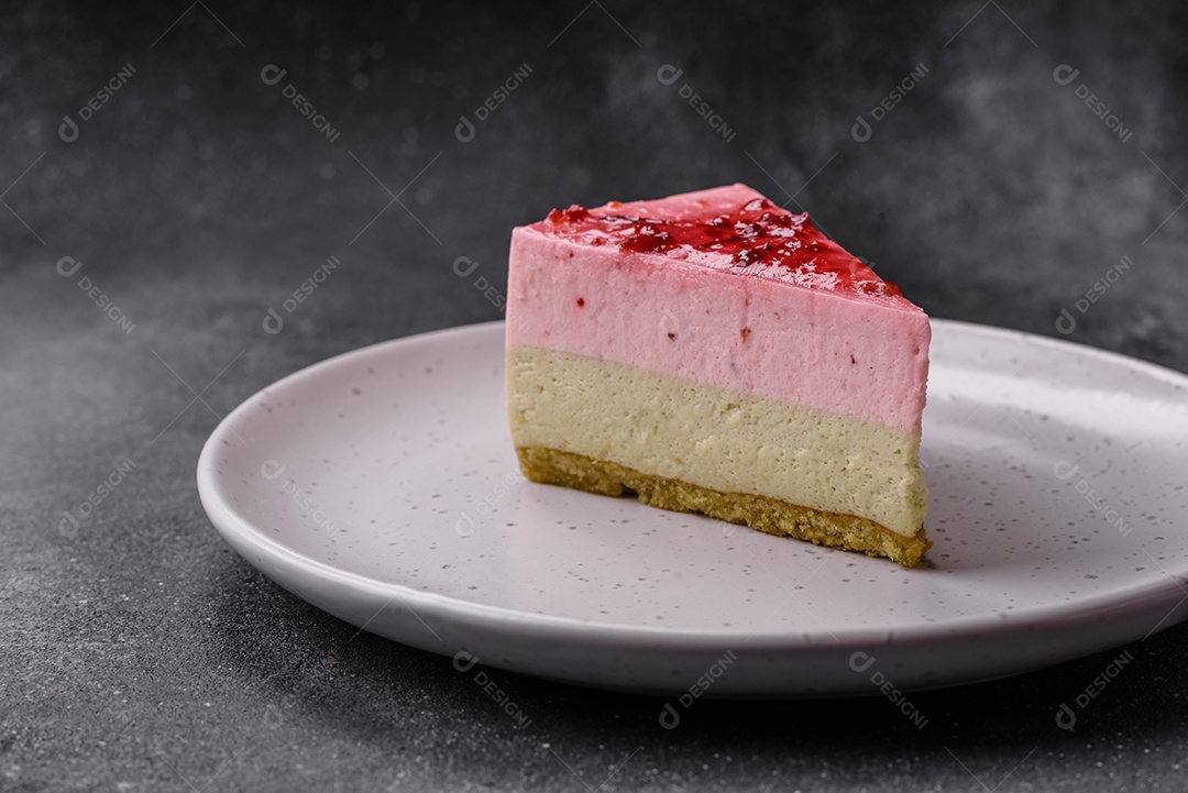 Delicioso cheesecake de sobremesa doce com sabor de framboesa e pistache em fundo de concreto texturizado