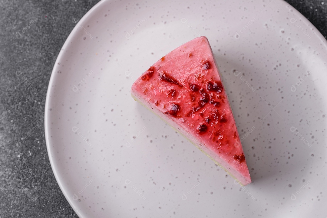 Delicioso cheesecake de sobremesa doce com sabor de framboesa e pistache em fundo de concreto texturizado