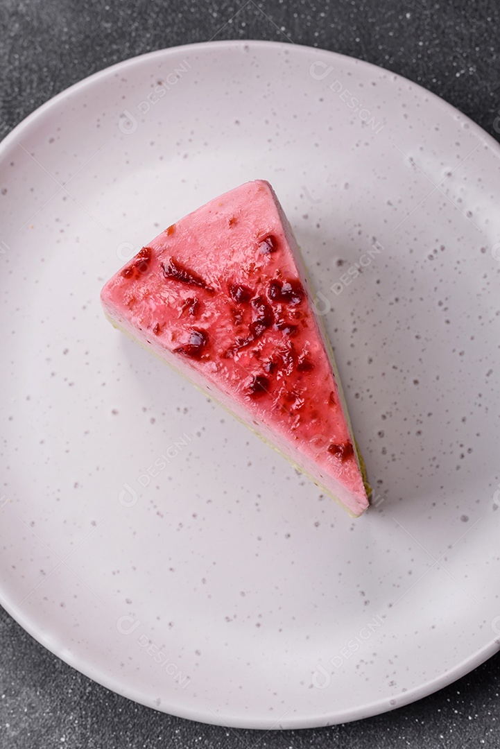 Delicioso cheesecake de sobremesa doce com sabor de framboesa e pistache em fundo de concreto texturizado