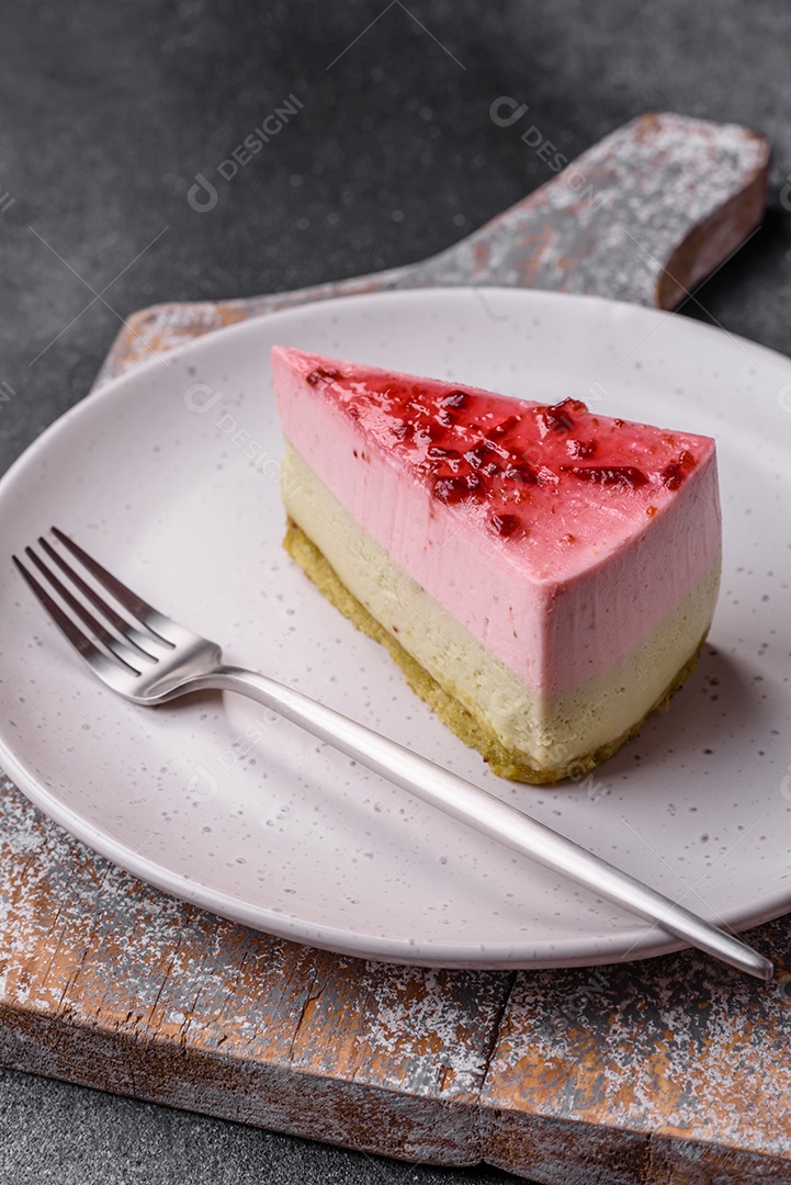 Delicioso cheesecake de sobremesa doce com sabor de framboesa e pistache em fundo de concreto texturizado