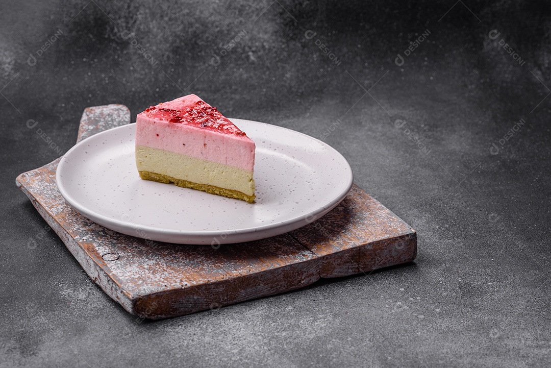 Delicioso cheesecake de sobremesa doce com sabor de framboesa e pistache em fundo de concreto texturizado