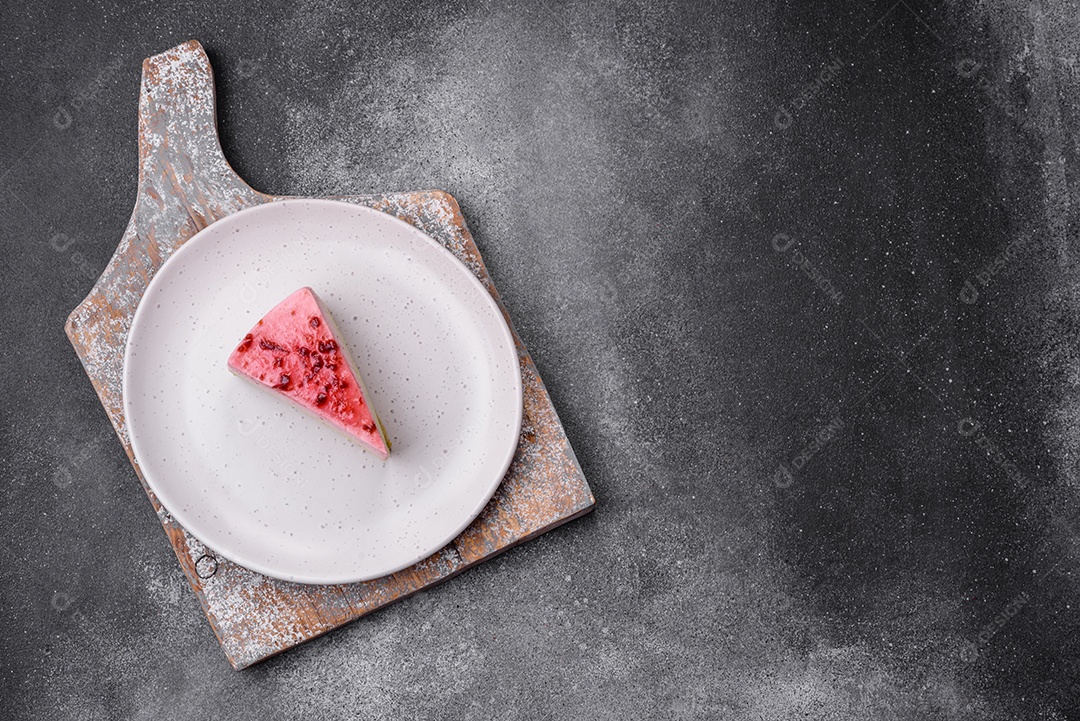 Delicioso cheesecake de sobremesa doce com sabor de framboesa e pistache em fundo de concreto texturizado