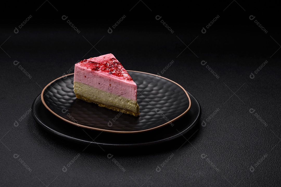 Delicioso cheesecake de sobremesa doce com sabor de framboesa e pistache em fundo de concreto texturizado