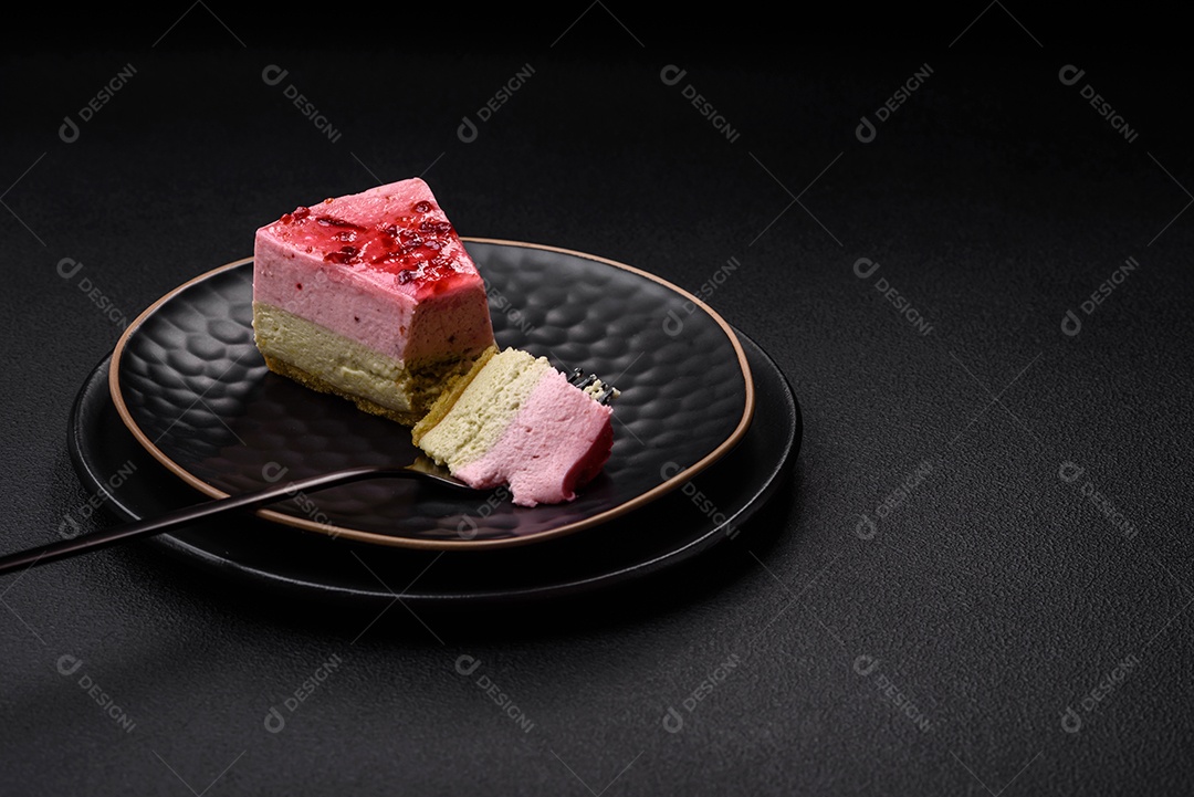 Delicioso cheesecake de sobremesa doce com sabor de framboesa e pistache em fundo de concreto texturizado