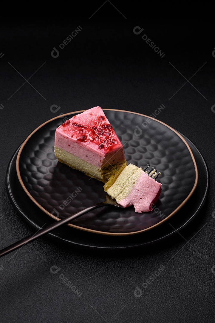 Delicioso cheesecake de sobremesa doce com sabor de framboesa e pistache em fundo de concreto texturizado