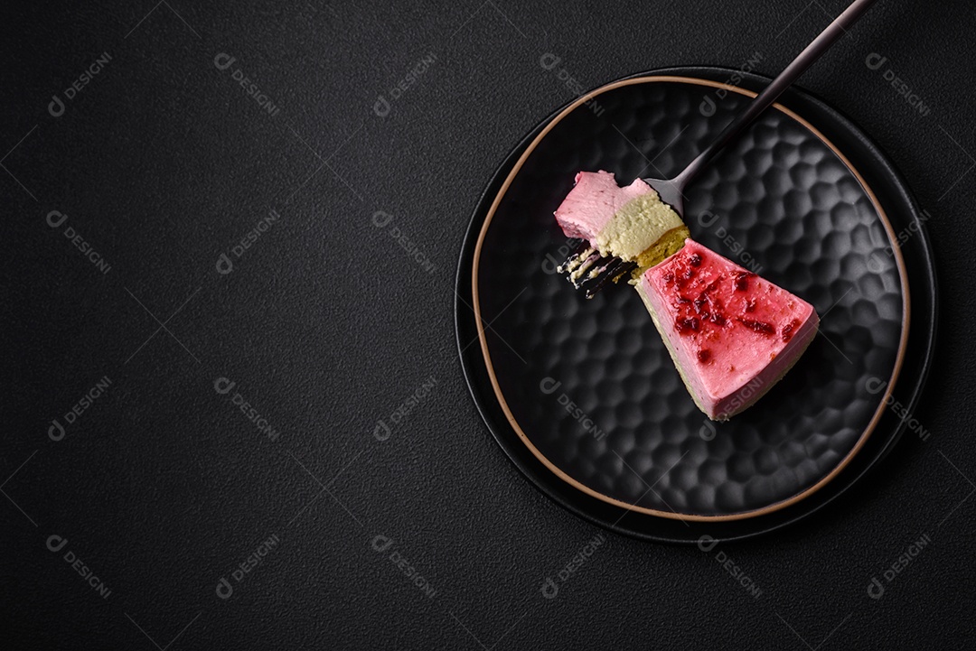 Delicioso cheesecake de sobremesa doce com sabor de framboesa e pistache em fundo de concreto texturizado