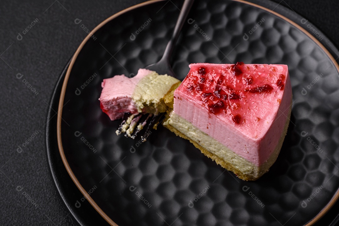Delicioso cheesecake de sobremesa doce com sabor de framboesa e pistache em fundo de concreto texturizado