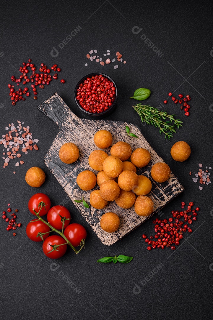 Ingredientes para cozinhar tomate cereja, sal, especiarias e ervas sobre um fundo escuro de concreto