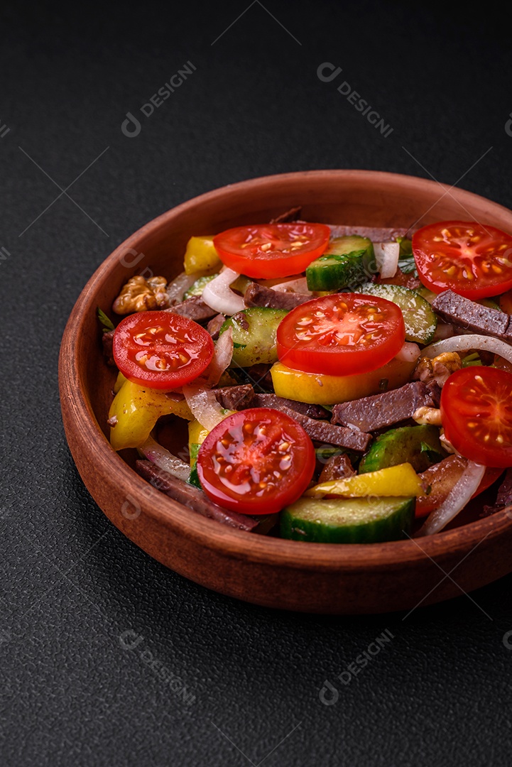 Deliciosa salada fresca com fatias de carne, tomate cereja, pimentão, sal, especiarias e ervas sobre um fundo de concreto texturizado