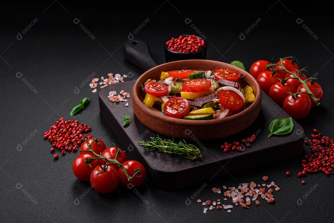 Deliciosa salada fresca com fatias de carne, tomate cereja, pimentão, sal, especiarias e ervas sobre um fundo de concreto texturizado