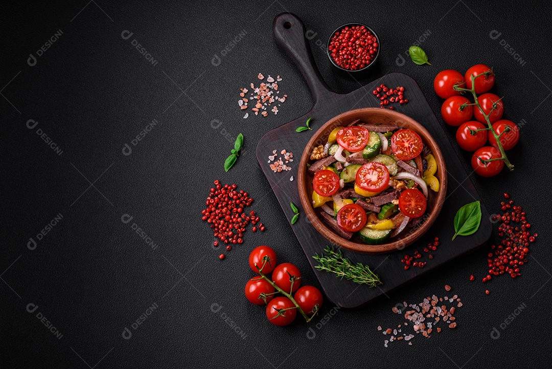 Deliciosa salada fresca com fatias de carne, tomate cereja, pimentão, sal, especiarias e ervas sobre um fundo de concreto texturizado