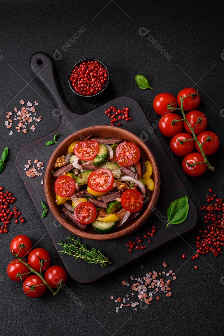 Deliciosa salada fresca com fatias de carne, tomate cereja, pimentão, sal, especiarias e ervas sobre um fundo de concreto texturizado