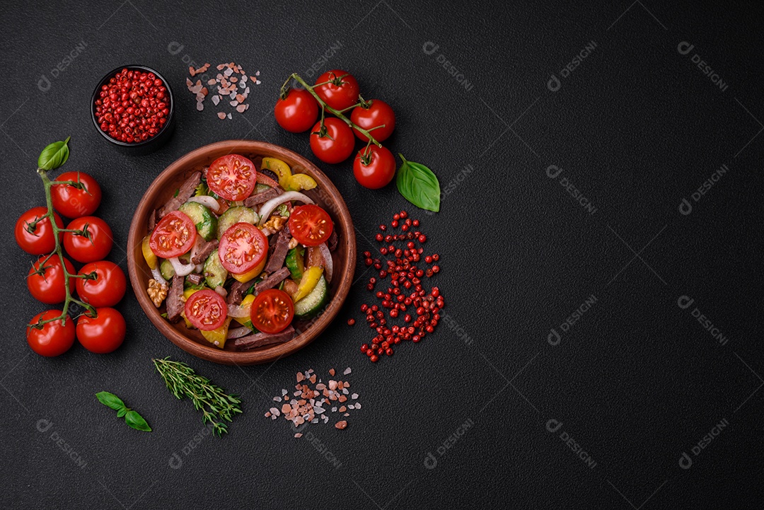 Deliciosa salada fresca com fatias de carne, tomate cereja, pimentão, sal, especiarias e ervas sobre um fundo de concreto texturizado