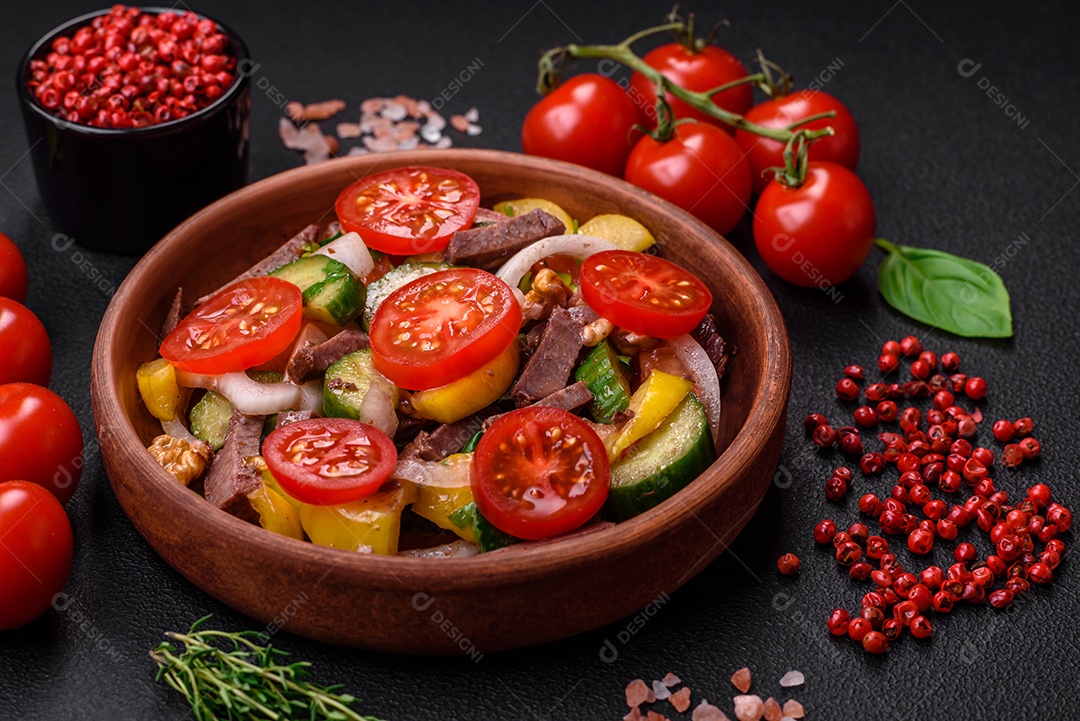 Deliciosa salada fresca com fatias de carne, tomate cereja, pimentão, sal, especiarias e ervas sobre um fundo de concreto texturizado