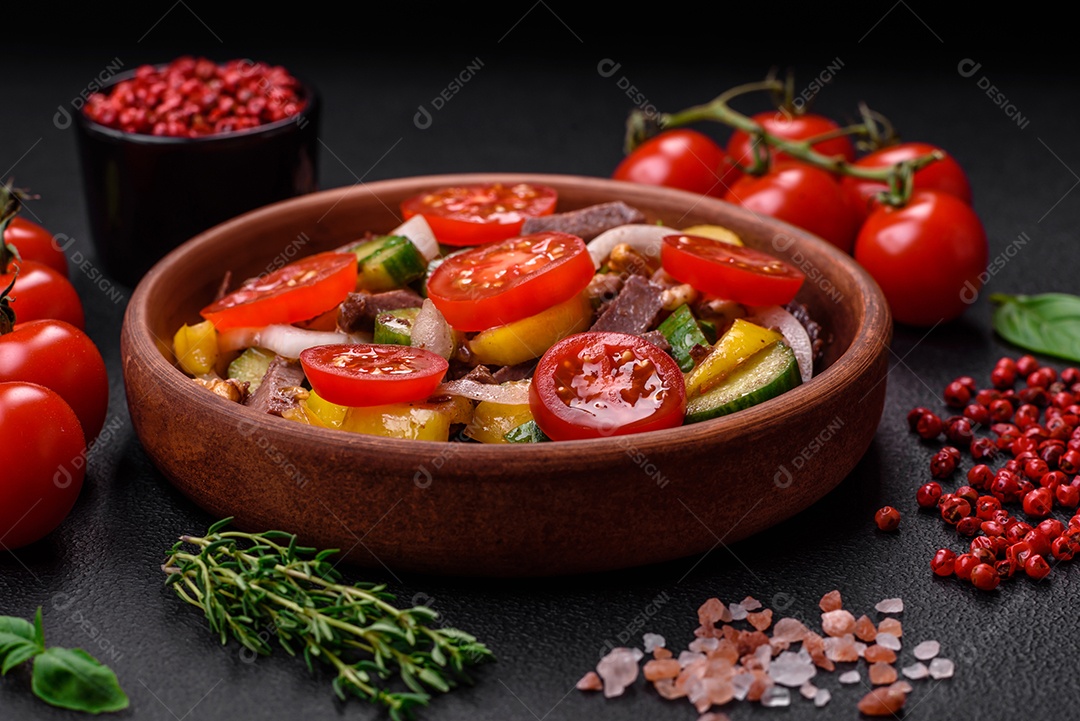Deliciosa salada fresca com fatias de carne, tomate cereja, pimentão, sal, especiarias e ervas sobre um fundo de concreto texturizado