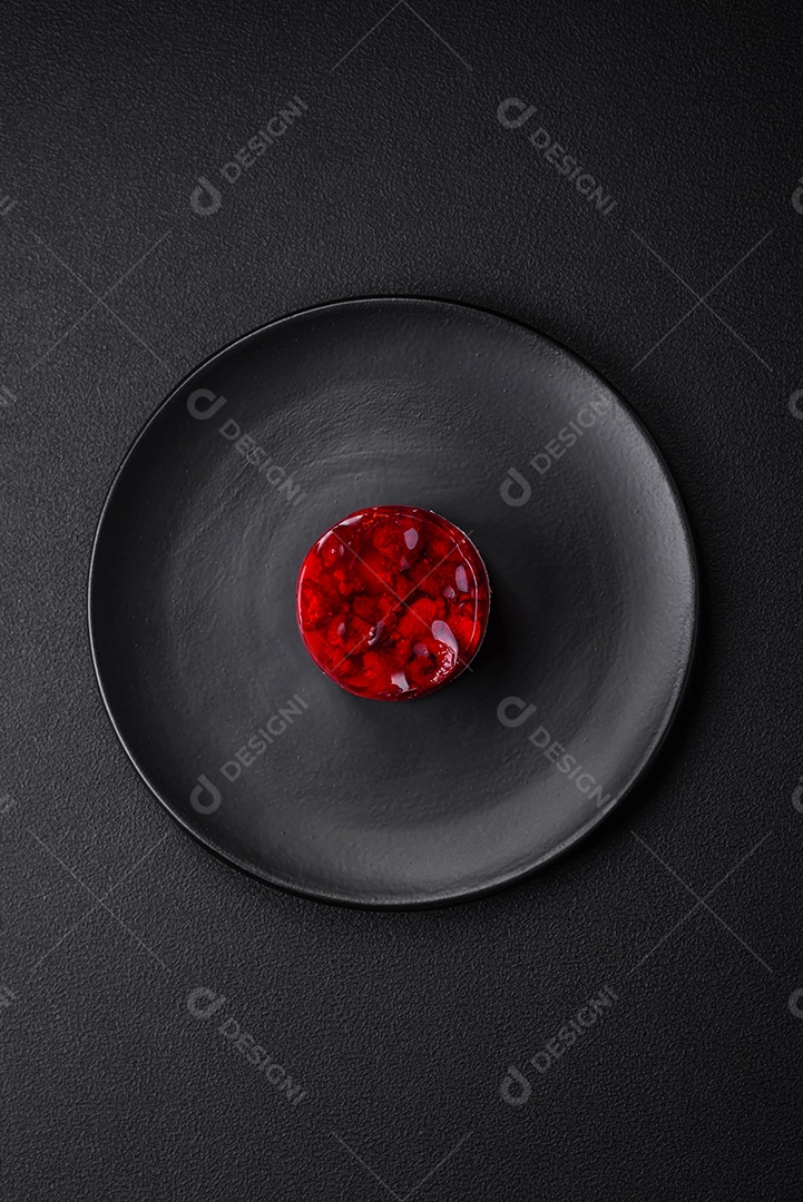 Delicioso bolo de queijo doce fresco com frutas e geleia de cor vermelha sobre um fundo escuro de concreto