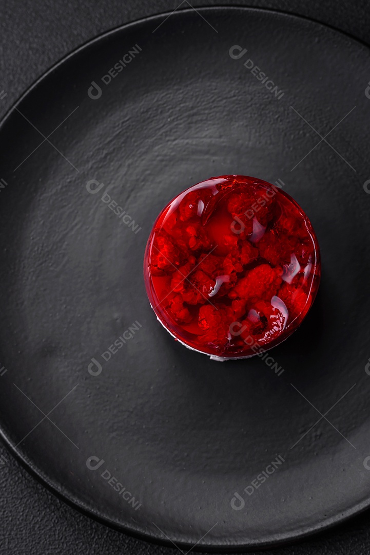 Delicioso bolo de queijo doce fresco com frutas e geleia de cor vermelha sobre um fundo escuro de concreto