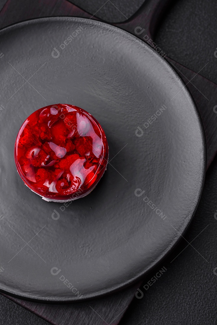 Delicioso bolo de queijo doce fresco com frutas e geleia de cor vermelha sobre um fundo escuro de concreto