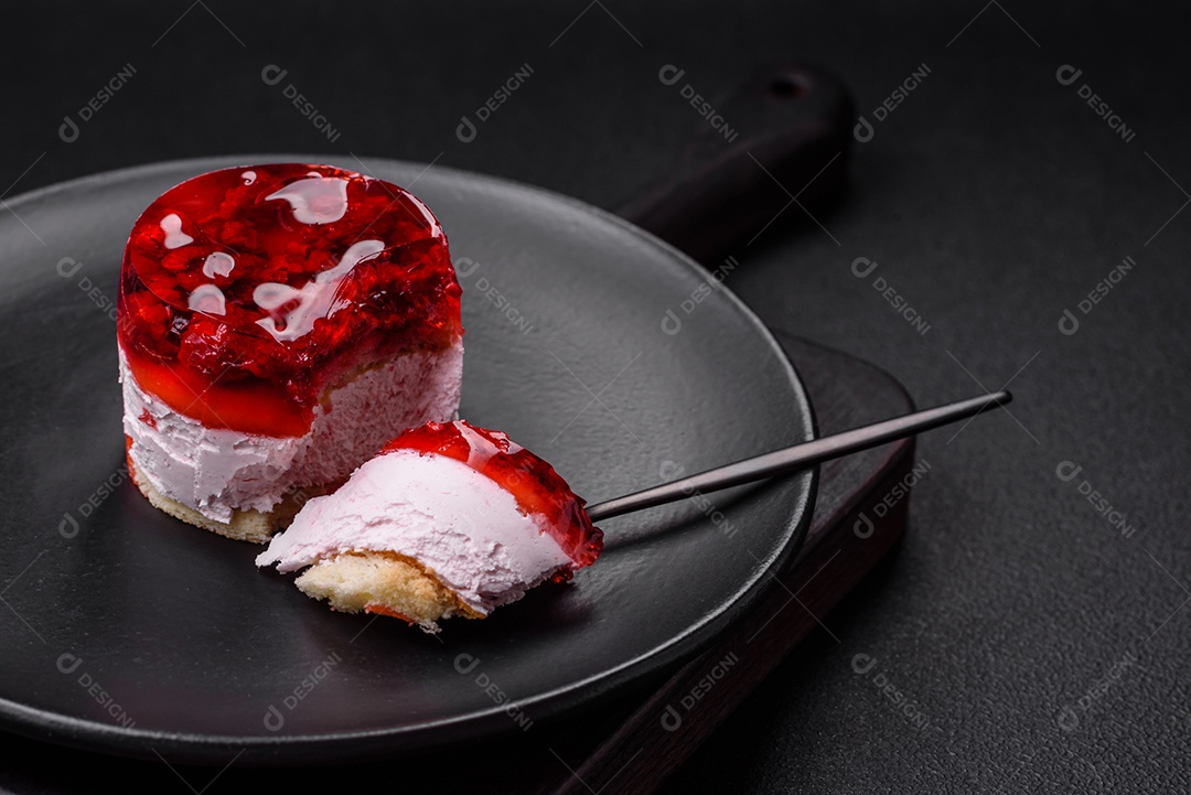 Delicioso bolo de queijo doce fresco com frutas e geleia de cor vermelha sobre um fundo escuro de concreto